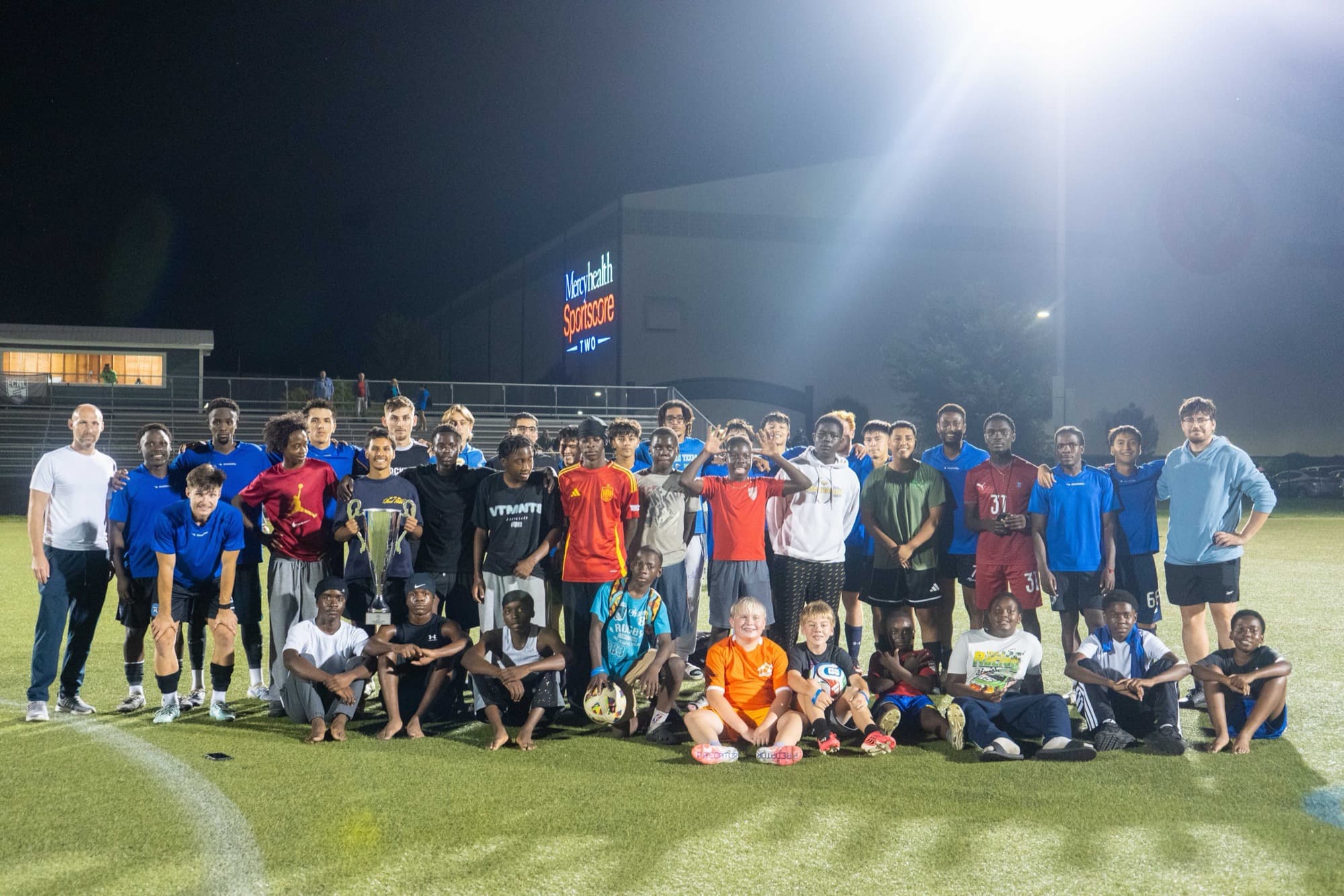 Rockford FC players, academy kids, and staff with the 2026 GCSL U23 trophy at Mercyhealth Sportscore Two